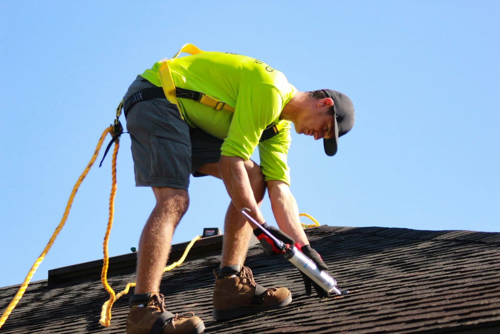A roofer working on a shingle roof