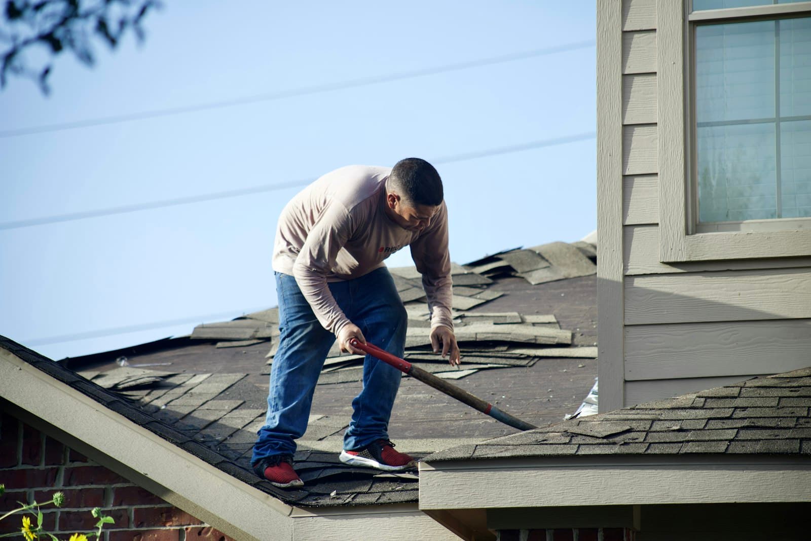 Tearing off storm-damaged shingles
